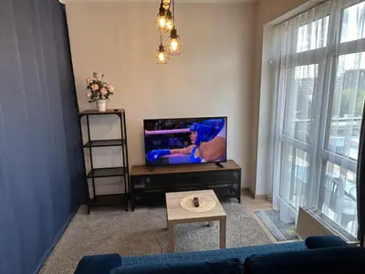 a living room with a tv and a couch at Your Home - Stylish Studio Apartment in Center, with Balcony & Self Check-in in Vilnius