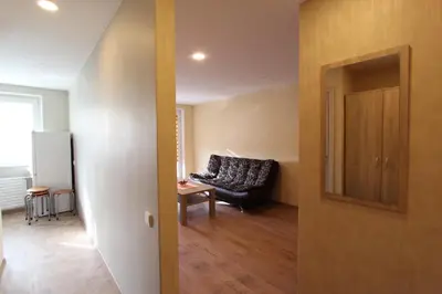 a living room with a black couch and a table at Sondeckio Apartment in Šiauliai