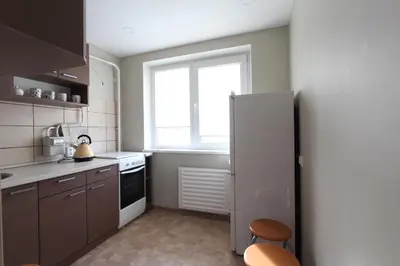 a kitchen with a refrigerator and a window at Sondeckio Apartment in Šiauliai