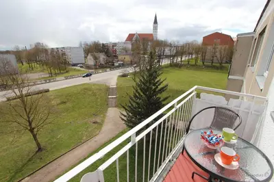 a balcony with a table with cups and candy on it at Tilžės Apartment in Šiauliai