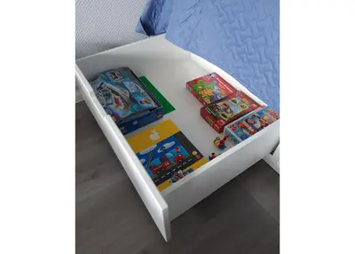 a white bed with two books on it at Alytus Ziburio studio in Alytus