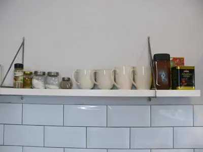 a shelf with a bunch of white vases on it at Alytus Ziburio studio in Alytus
