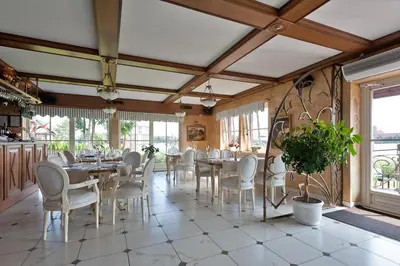 a dining room with tables and chairs and windows at Viva Trakai in Trakai