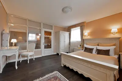 a bedroom with a large bed and a desk at Viva Trakai in Trakai