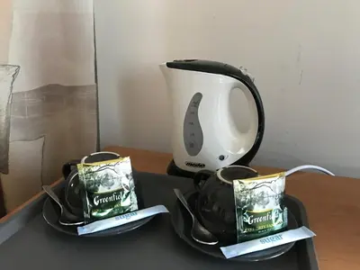a tea kettle and two cups on a table at Alanta 