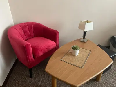 a red chair sitting next to a table with a lamp at Alanta 