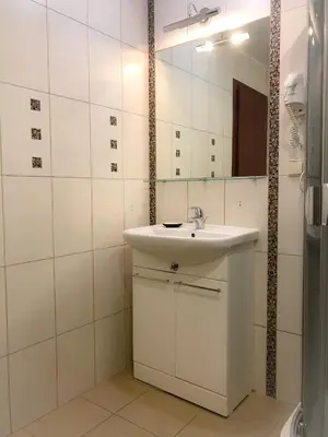 a white bathroom with a sink and a mirror at Alanta 