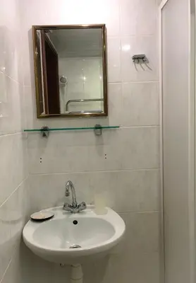 a white bathroom with a sink and a mirror at Alanta 