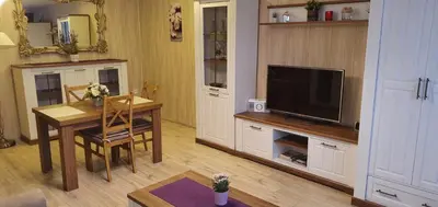 a living room with a table and a television at Marijampolės jaukūs apartamentai in Marijampolė
