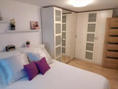 a bedroom with a white bed with purple pillows at Marijampolės jaukūs apartamentai in Marijampolė