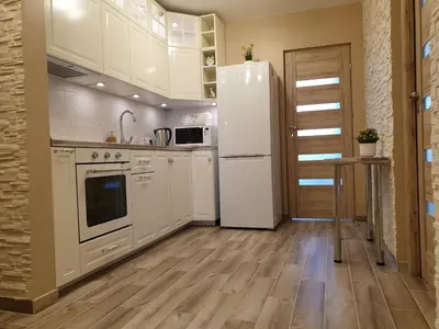 a kitchen with white appliances and a white refrigerator at Marijampolės jaukūs apartamentai in Marijampolė
