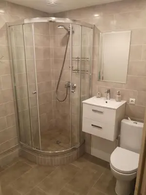 a bathroom with a shower and a toilet and a sink at Parko apartamentai in Panevėžys