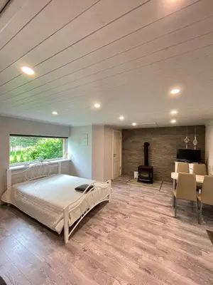 a bedroom with a bed and a table and a fireplace at Sodyba 
