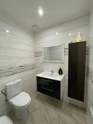 a white bathroom with a toilet and a sink at Sodyba 