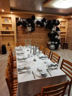 a long table in a room with black balloons at Sodyba 