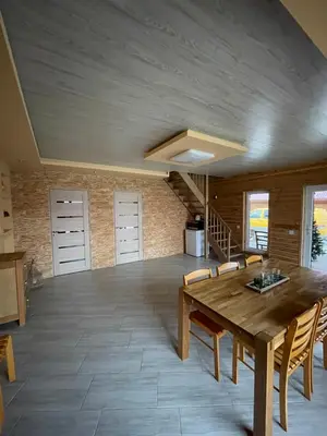 a dining room with a wooden table and chairs at Sodyba 
