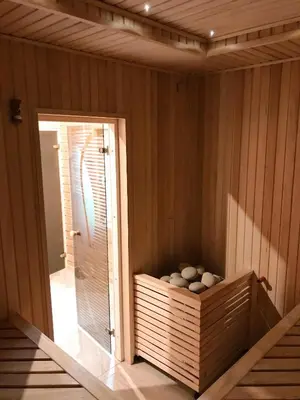 a room with a sauna with a wooden wall at Sodyba 