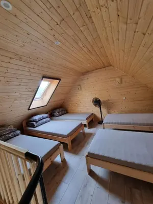 a room with three beds in a wooden cabin at Sodyba 