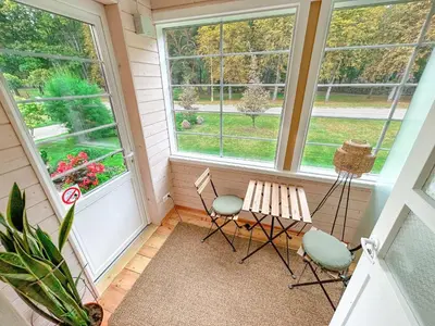 a screened in porch with two chairs and a bench at Zofija in Birštonas