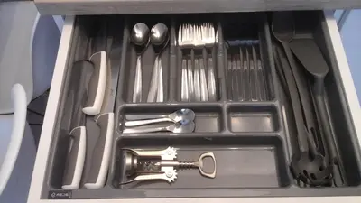 a drawer full of kitchen utensils with aocrates at Relax apartments near Egle in Druskininkai