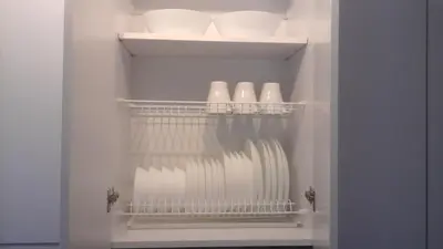 a white refrigerator with white dishes in it at Relax apartments near Egle in Druskininkai