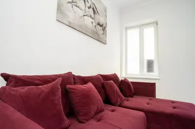 a red couch with pillows in a living room at Kaunas Castle Apartments - One bedroom flat in Kaunas