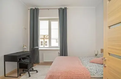 a bedroom with a desk and a bed and a window at Kaunas Castle Apartments - One bedroom flat in Kaunas