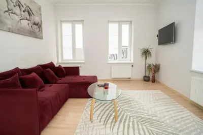 a living room with a red couch and a glass table at Kaunas Castle Apartments - One bedroom flat in Kaunas