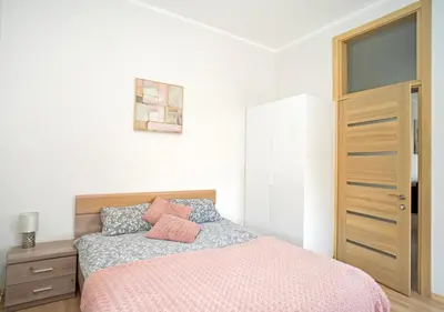 a bedroom with a bed with a pink comforter at Kaunas Castle Apartments - One bedroom flat in Kaunas