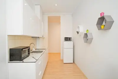 a white kitchen with a sink and a microwave at Kaunas Castle Apartments - One bedroom flat in Kaunas