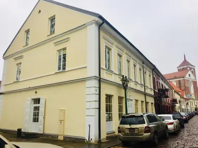 a white building on a street with parked cars at Kaunas Castle Apartments - One bedroom flat in Kaunas