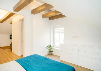 a white bedroom with a blue bed and a window at Kaunas Castle Apartments - Studio in Kaunas