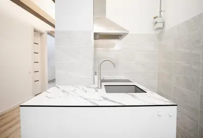 a kitchen with white marble countertops and a sink at Kaunas Castle Apartments - Studio in Kaunas
