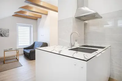 a kitchen with a sink and a couch in a room at Kaunas Castle Apartments - Studio in Kaunas