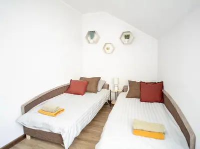 two twin beds in a room with white walls at Kaunas Castle Apartments - 2 Bedroom Flat in Kaunas