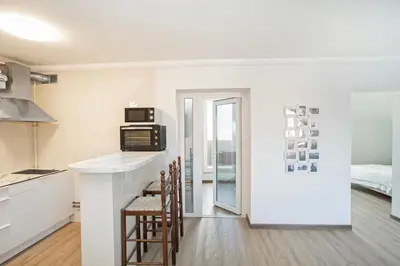 a kitchen with a counter and chairs in a room at Kaunas Castle Apartments - 2 Bedroom Flat in Kaunas