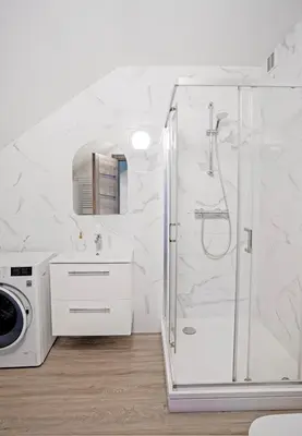a bathroom with a shower and a washing machine at Kaunas Castle Apartments - 2 Bedroom Flat in Kaunas