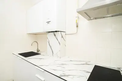 a kitchen with white marble counter tops and a sink at Kaunas Castle Apartments - 2 Bedroom Flat in Kaunas