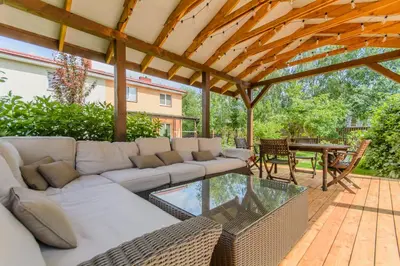 a patio with a sectional couch and a table at Bedugnės pirtelė - Cosy Sauna House in Vilnius