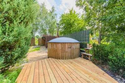 a wooden deck with a gazebo and a bench at Bedugnės pirtelė - Cosy Sauna House in Vilnius
