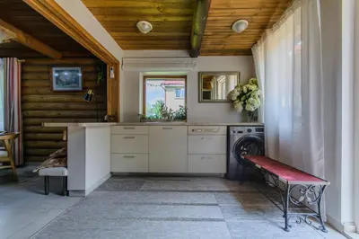 a kitchen with white cabinets and a red bench at Bedugnės pirtelė - Cosy Sauna House in Vilnius