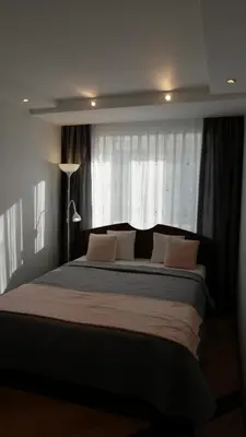 a bedroom with a large bed in front of a window at Dange apartment in Šiauliai