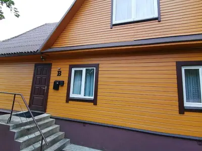 a wooden house with stairs and a door at Karolio Sodyba Palūšėje in Palūšė