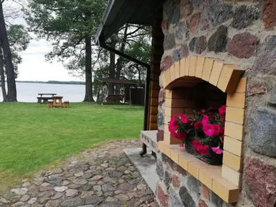 a brick oven with pink flowers in it at Karolio Sodyba Palūšėje in Palūšė