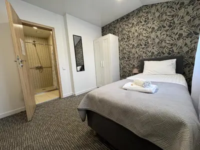 a bedroom with a bed with two towels on it at Grey apartments 