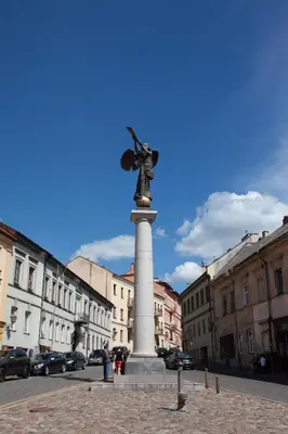 a statue of a woman on a pillar in a street at Brand new flat heart of Vilnius in Vilnius