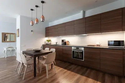 a kitchen with wooden cabinets and a table and chairs at Brand new flat heart of Vilnius in Vilnius