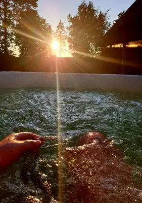 a person in the water with the sun in the background at Remigija Studio Home in Jonava