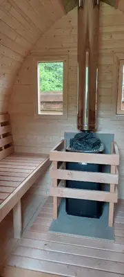 a sauna with a stove in a wooden cabin at Remigija Studio Home in Jonava