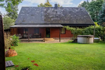 a log cabin with a large yard in front of it at Remigija Studio Home in Jonava